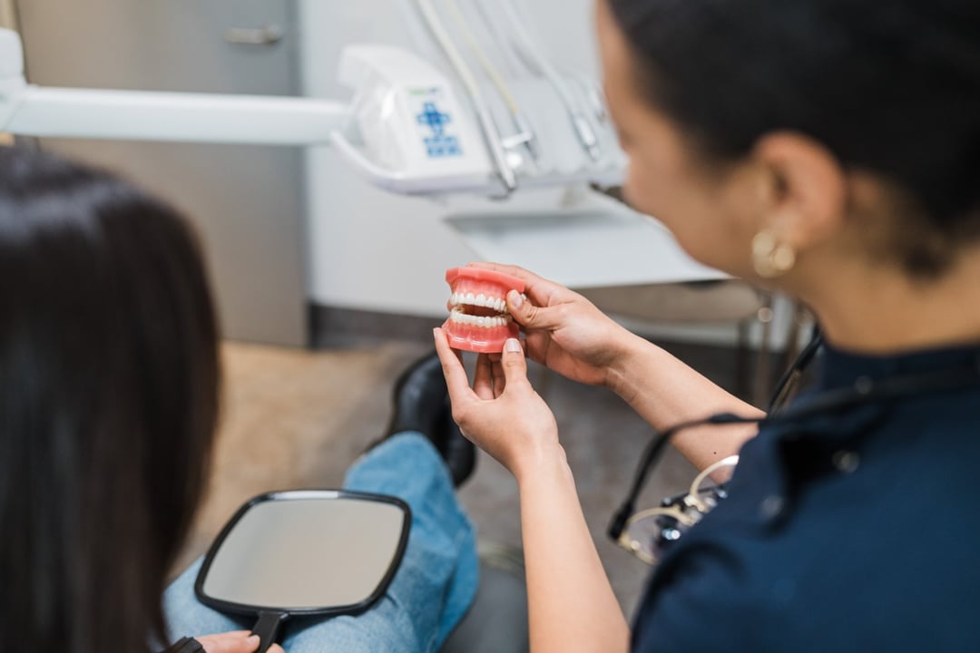An Innova Dental dentist using a teeth model to explain treatment options to a patient